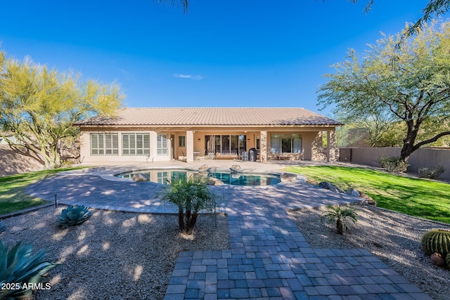 back of property featuring a fenced in pool, a fenced backyard, stucco siding, a patio area, and a lawn