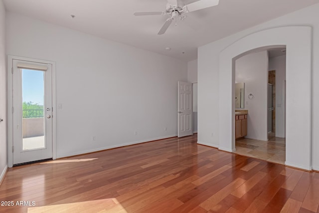 16600 N Thompson Peak Pkwy Unit 1072, Scottsdale, AZ 85260 - empty room with a ceiling fan, light wood-style flooring, arched walkways, and baseboards