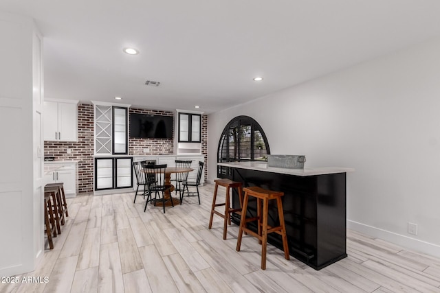dining area with indoor bar, recessed lighting, baseboards, visible vents, and wood tiled floor