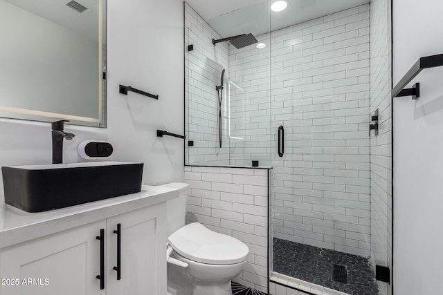 bathroom with a shower stall, visible vents, toilet, and vanity