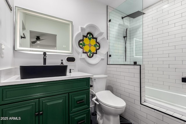 bathroom with toilet, vanity, and tiled shower / bath