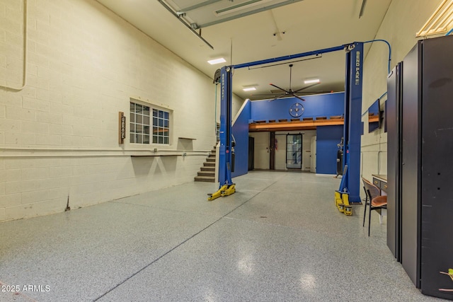 garage with concrete block wall and freestanding refrigerator