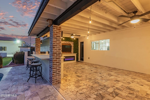 view of patio with outdoor dry bar and a ceiling fan