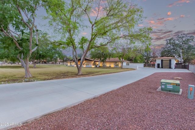view of front of home with fence, a front lawn, and concrete driveway