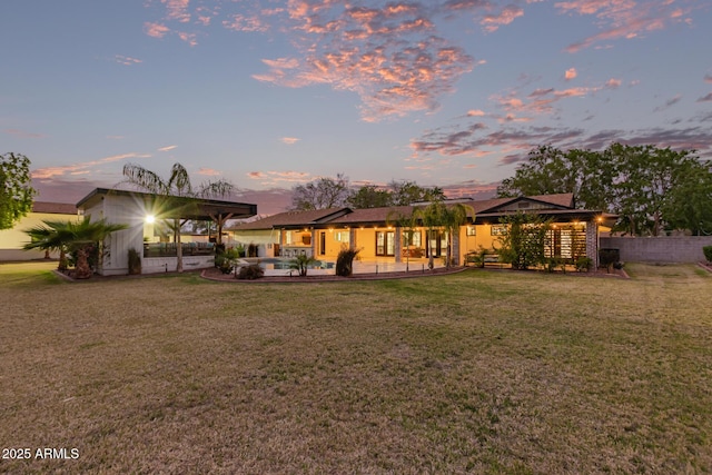 rear view of house featuring fence, a yard, and a patio