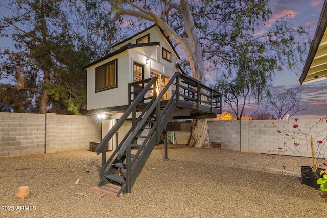 exterior space with a fenced backyard, a wooden deck, and stairway