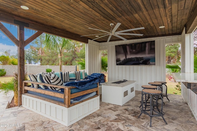 view of patio / terrace with an outdoor living space, fence, and a ceiling fan