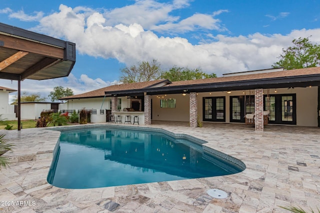 view of pool featuring a patio, french doors, and outdoor dry bar