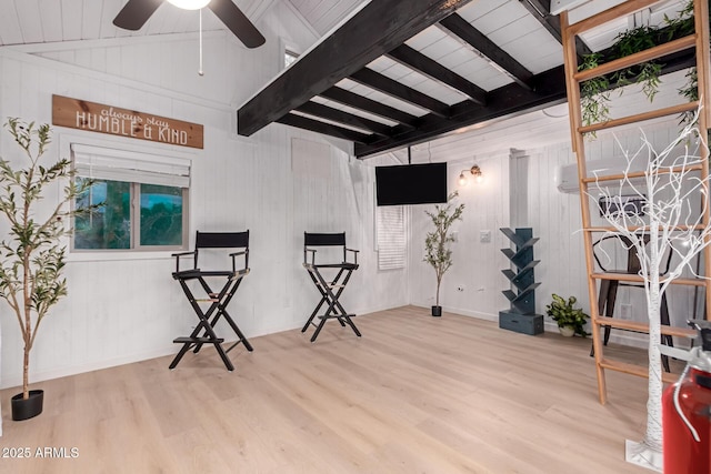 sitting room with a ceiling fan, vaulted ceiling with beams, and wood finished floors