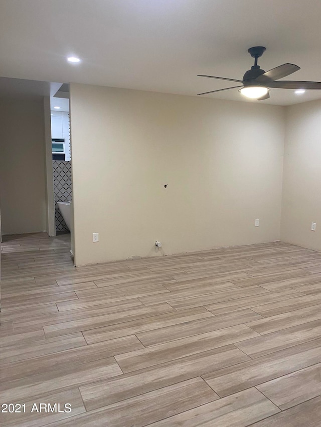 empty room featuring ceiling fan and light hardwood / wood-style flooring