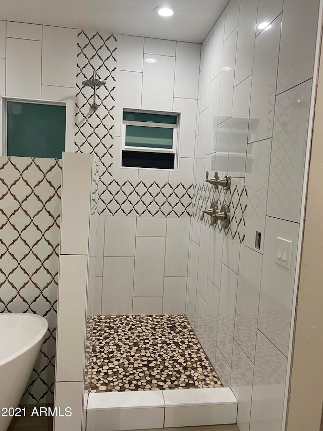 bathroom with tiled shower and tile walls