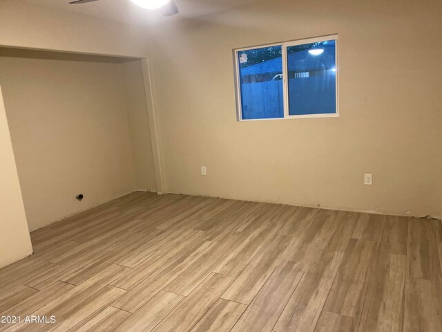 unfurnished room with light wood-type flooring and ceiling fan