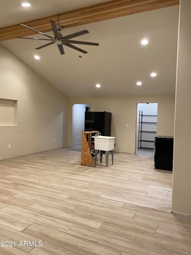 interior space featuring ceiling fan, lofted ceiling with beams, and light wood-type flooring