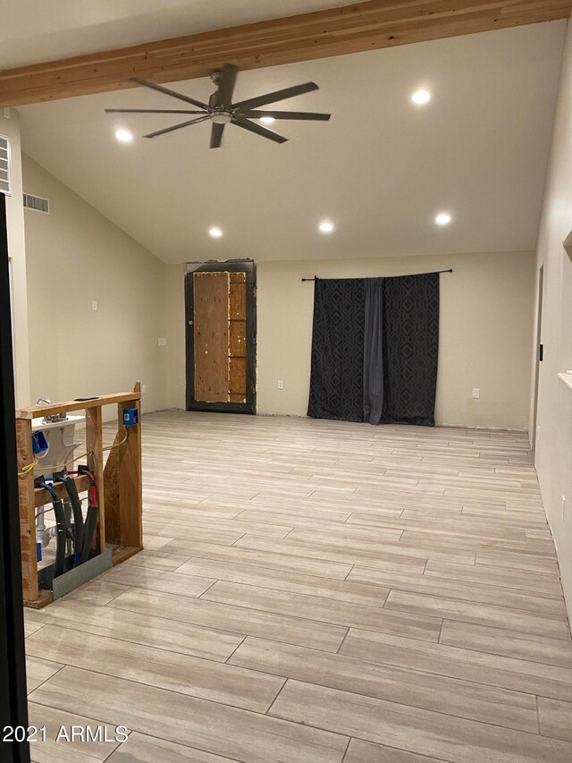 empty room featuring lofted ceiling with beams, ceiling fan, and light hardwood / wood-style flooring