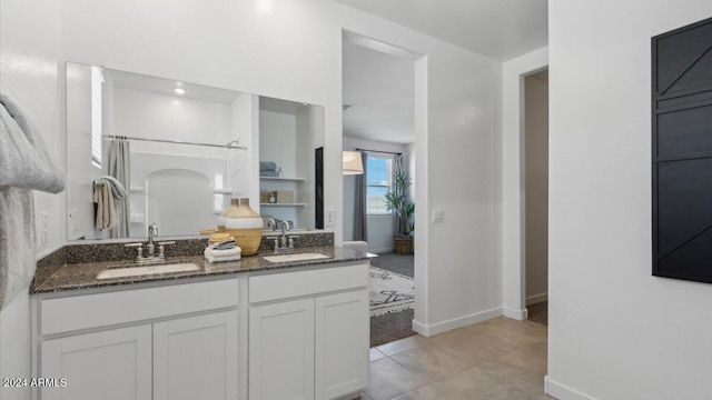 bathroom featuring vanity, tile patterned flooring, and a shower