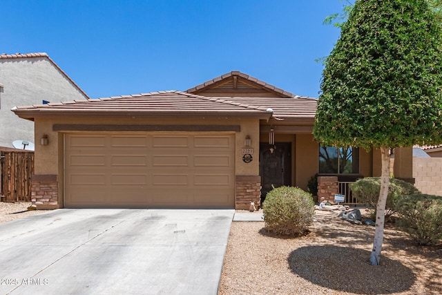 2223 S Hughes Dr, Buckeye, AZ 85326 - view of front of property with stone siding, driveway, an attached garage, and stucco siding