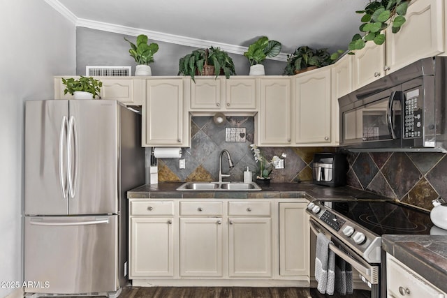 kitchen featuring dark countertops, backsplash, appliances with stainless steel finishes, ornamental molding, and a sink