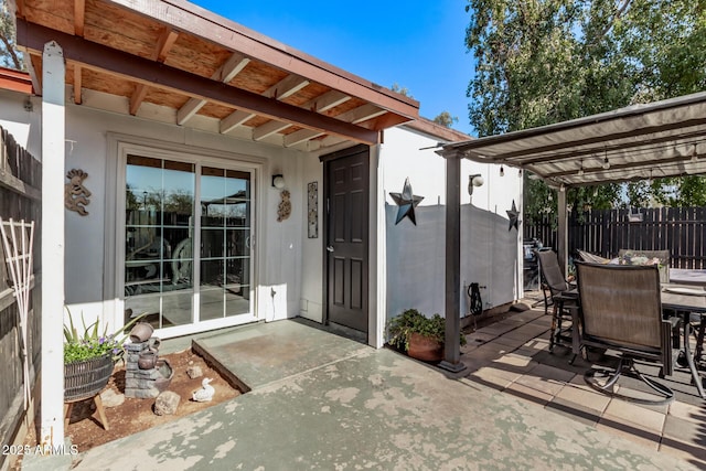 property entrance with a patio, fence, a pergola, and outdoor dining space