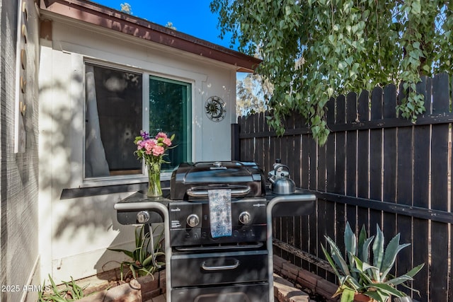 view of patio / terrace with a grill and fence