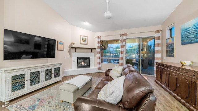 living area with light wood finished floors and a glass covered fireplace