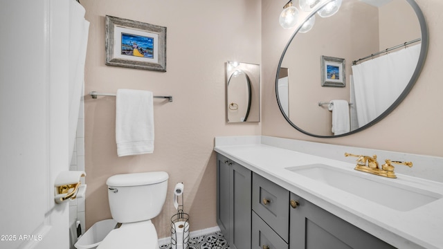 full bath with vanity, toilet, and baseboards