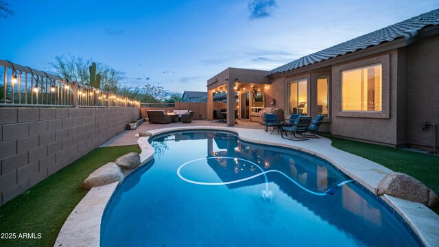 pool at dusk with an outdoor living space, a fenced backyard, and a patio area