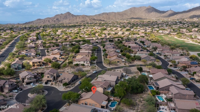 aerial view of property's location with a mountainous background and nearby suburban area