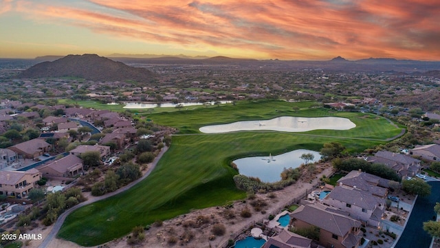 aerial view of property's location featuring nearby suburban area, a water and mountain view, and a golf course