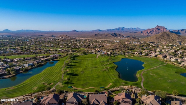 view of property location featuring nearby suburban area, a water and mountain view, and a local golf course