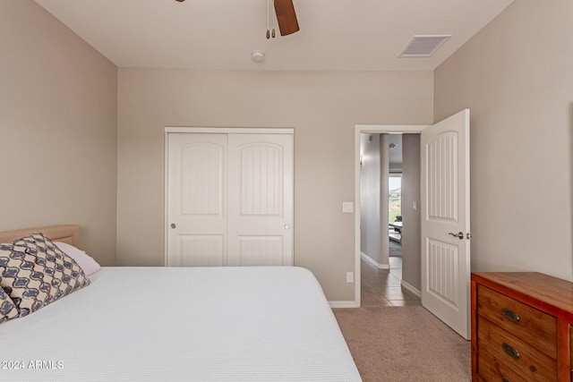 carpeted bedroom with ceiling fan and a closet