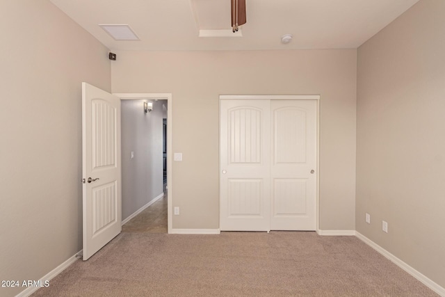 unfurnished bedroom with light colored carpet and a closet