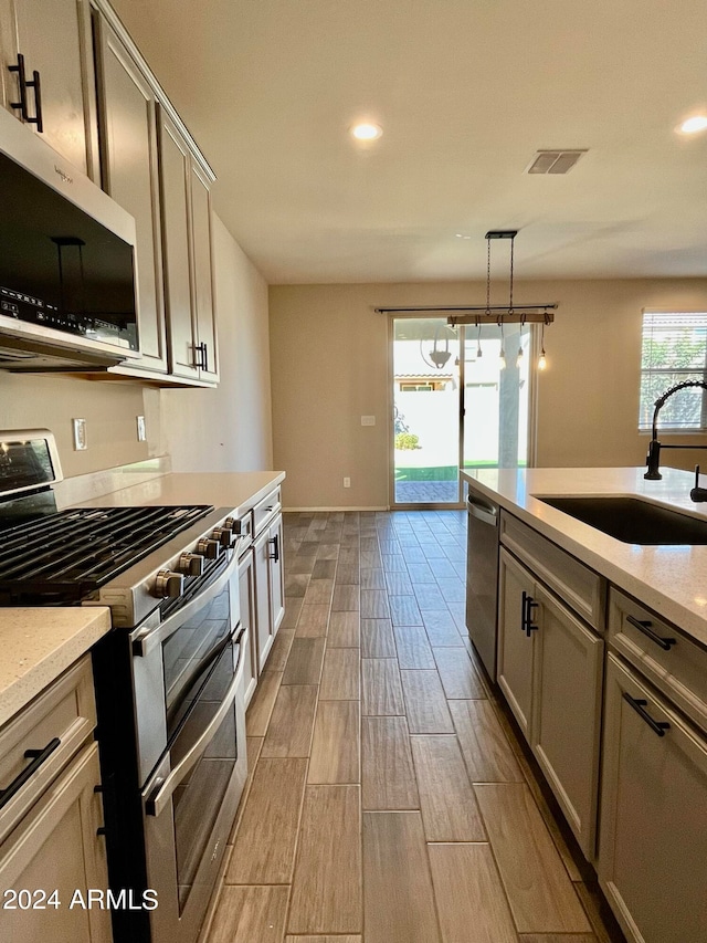 kitchen featuring sink, appliances with stainless steel finishes, and pendant lighting