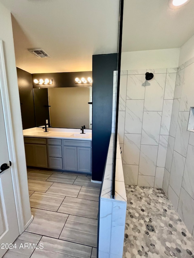 bathroom featuring a tile shower and vanity