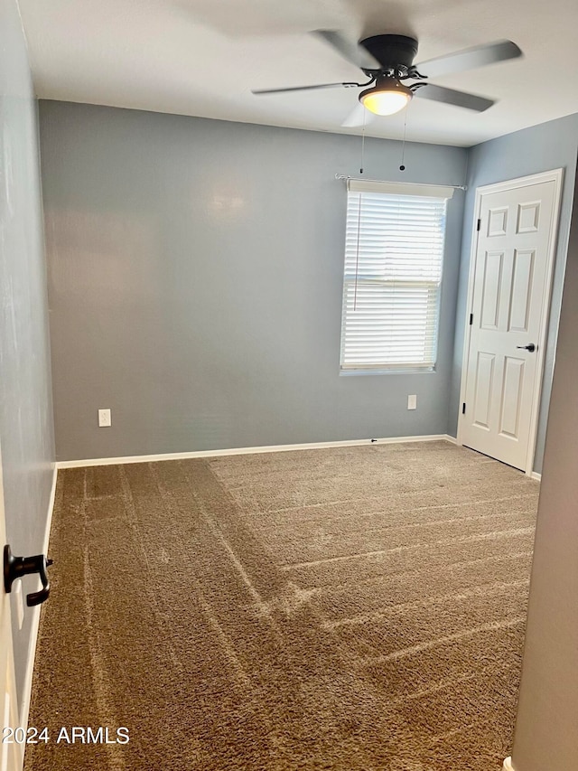 spare room featuring carpet and ceiling fan