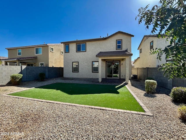 rear view of property featuring a yard and central air condition unit