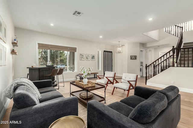 living room with an inviting chandelier and light hardwood / wood-style floors