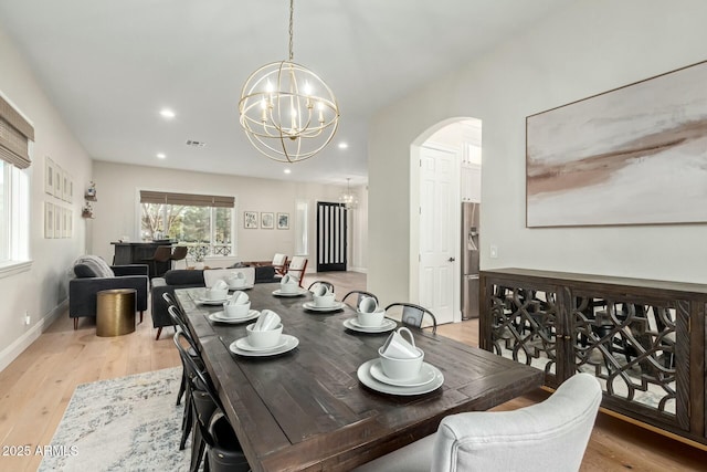 dining area featuring light hardwood / wood-style floors and a notable chandelier