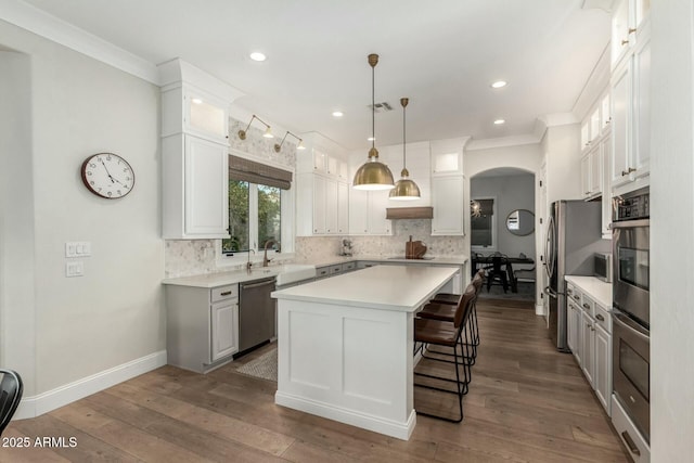 kitchen with backsplash, stainless steel appliances, a center island, and white cabinets