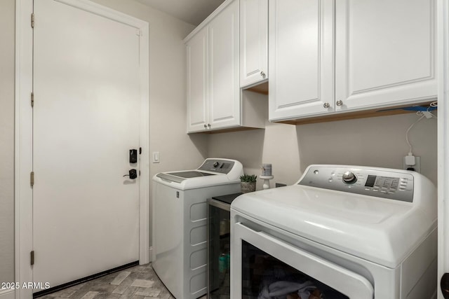 clothes washing area featuring cabinets and washing machine and dryer