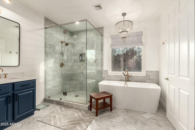 bathroom featuring vanity, a chandelier, and separate shower and tub