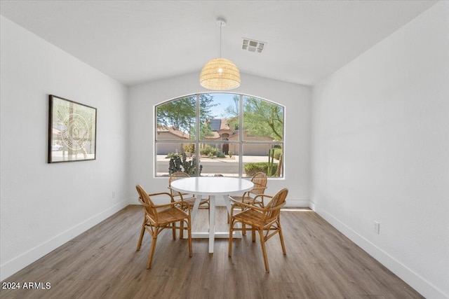 dining room with hardwood / wood-style flooring and lofted ceiling