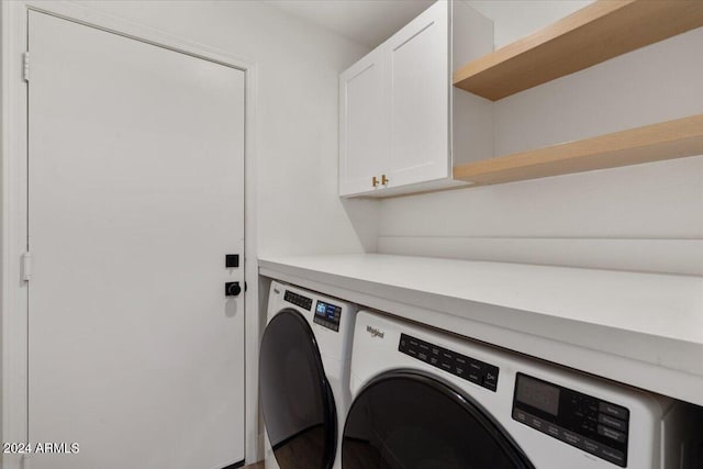 clothes washing area with washing machine and clothes dryer and cabinets