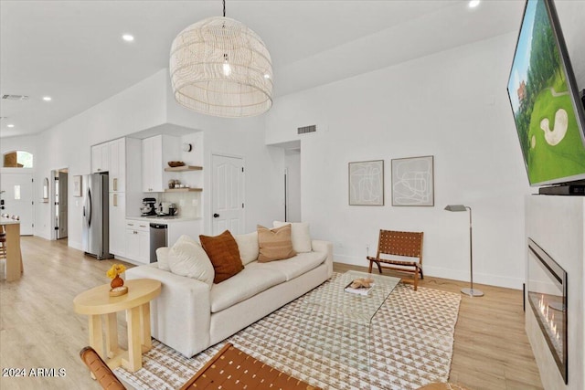 living room with a high ceiling and light hardwood / wood-style flooring