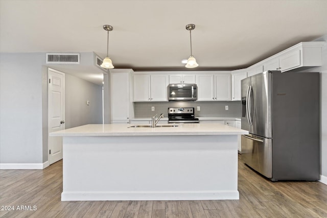 kitchen featuring white cabinetry, hanging light fixtures, stainless steel appliances, and sink