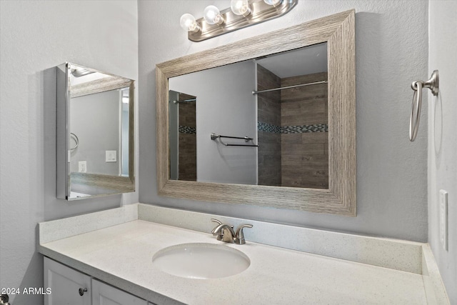 bathroom with vanity and tiled shower