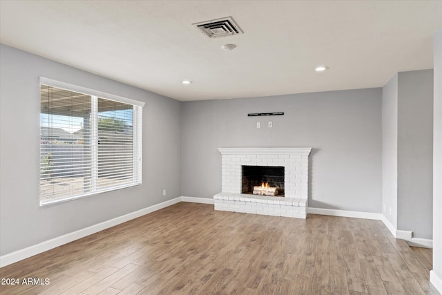 unfurnished living room featuring a fireplace and light hardwood / wood-style flooring