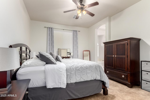 bedroom with arched walkways, ceiling fan, and visible vents