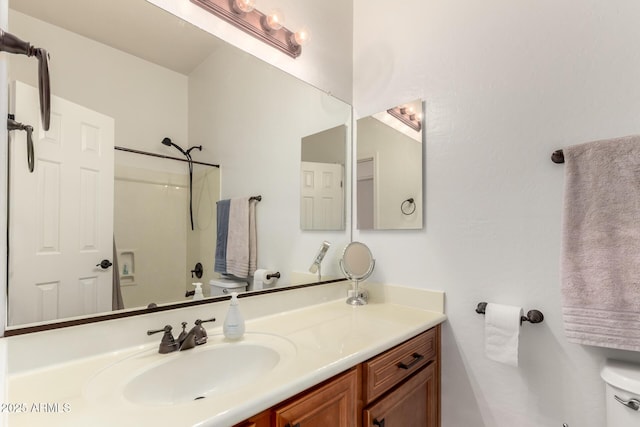 bathroom featuring a shower, toilet, and vanity