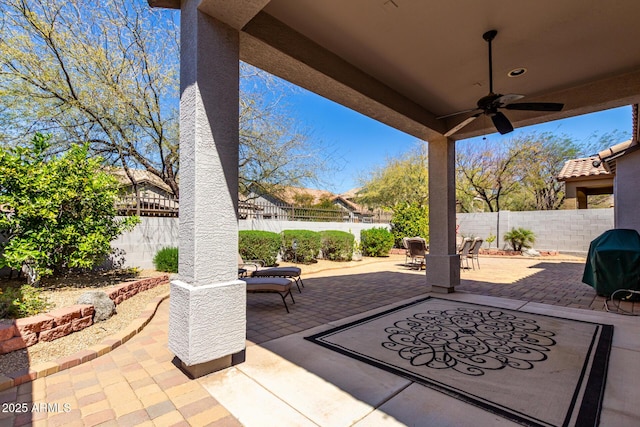 view of patio / terrace featuring a fenced backyard, outdoor dining space, area for grilling, and a ceiling fan