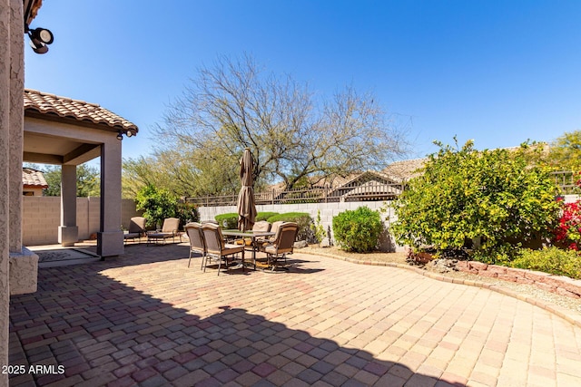 view of patio with outdoor dining area and a fenced backyard